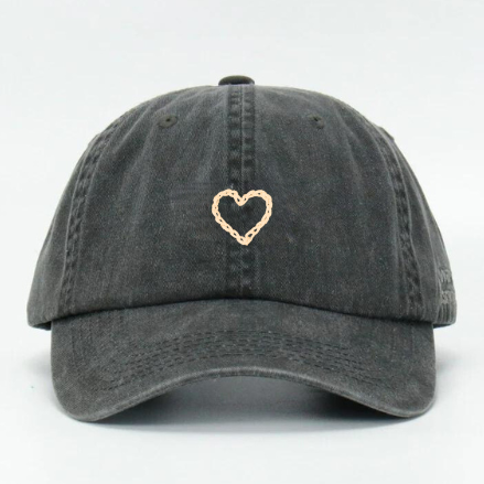 A black wash cotton baseball cap with a hand embroidered heart on the front panel.
