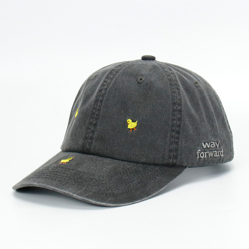 A black wash baseball cap with embroidered yellow duck designs on it, displayed against a plain background.
