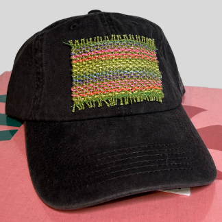 A black baseball cap with a multicolored handmade patch on the front