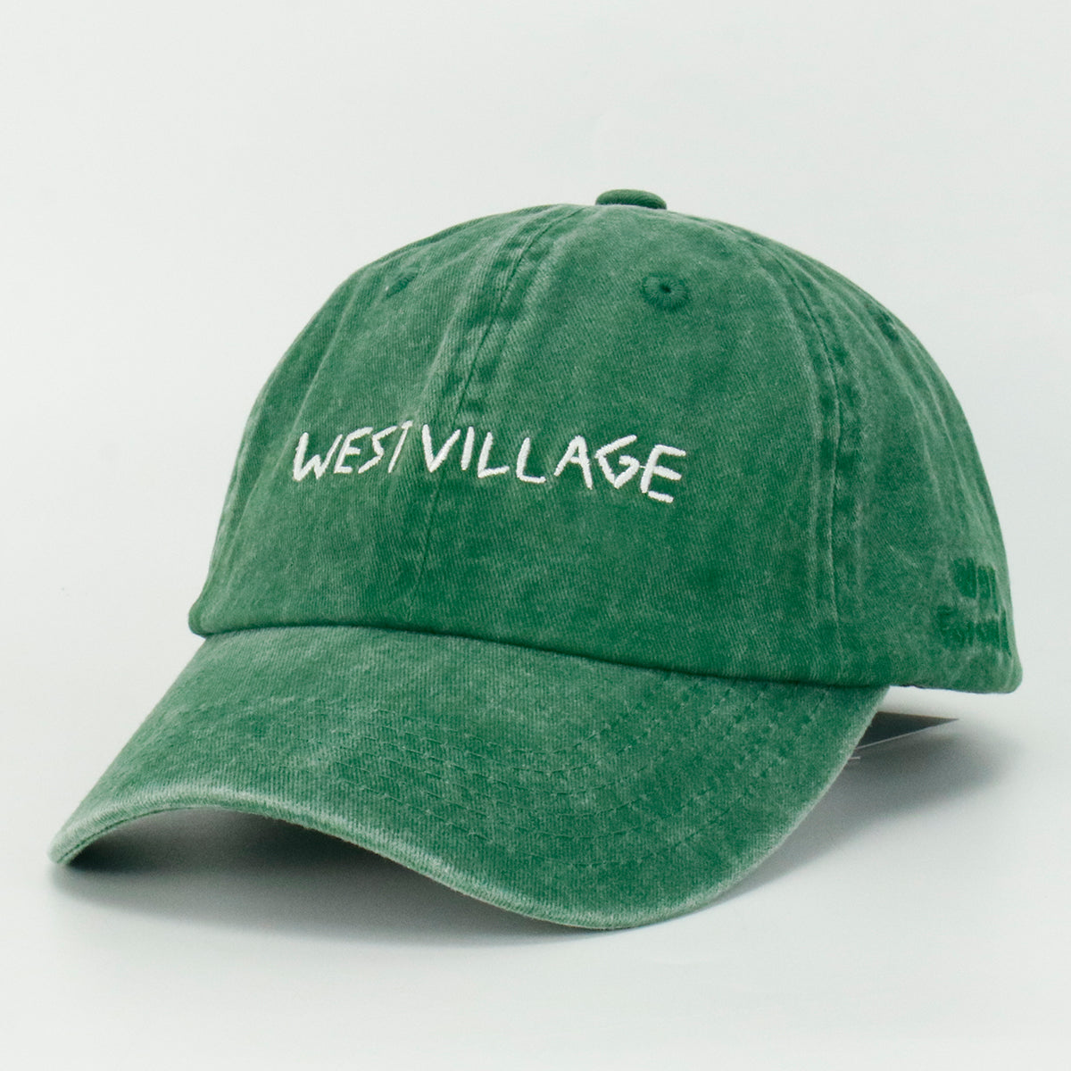 Green baseball cap with 'WEST VILLAGE' embroidered on the front.