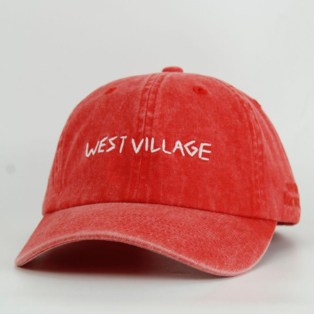 Red cap with 'WEST VILLAGE' embroidery on a light gray background