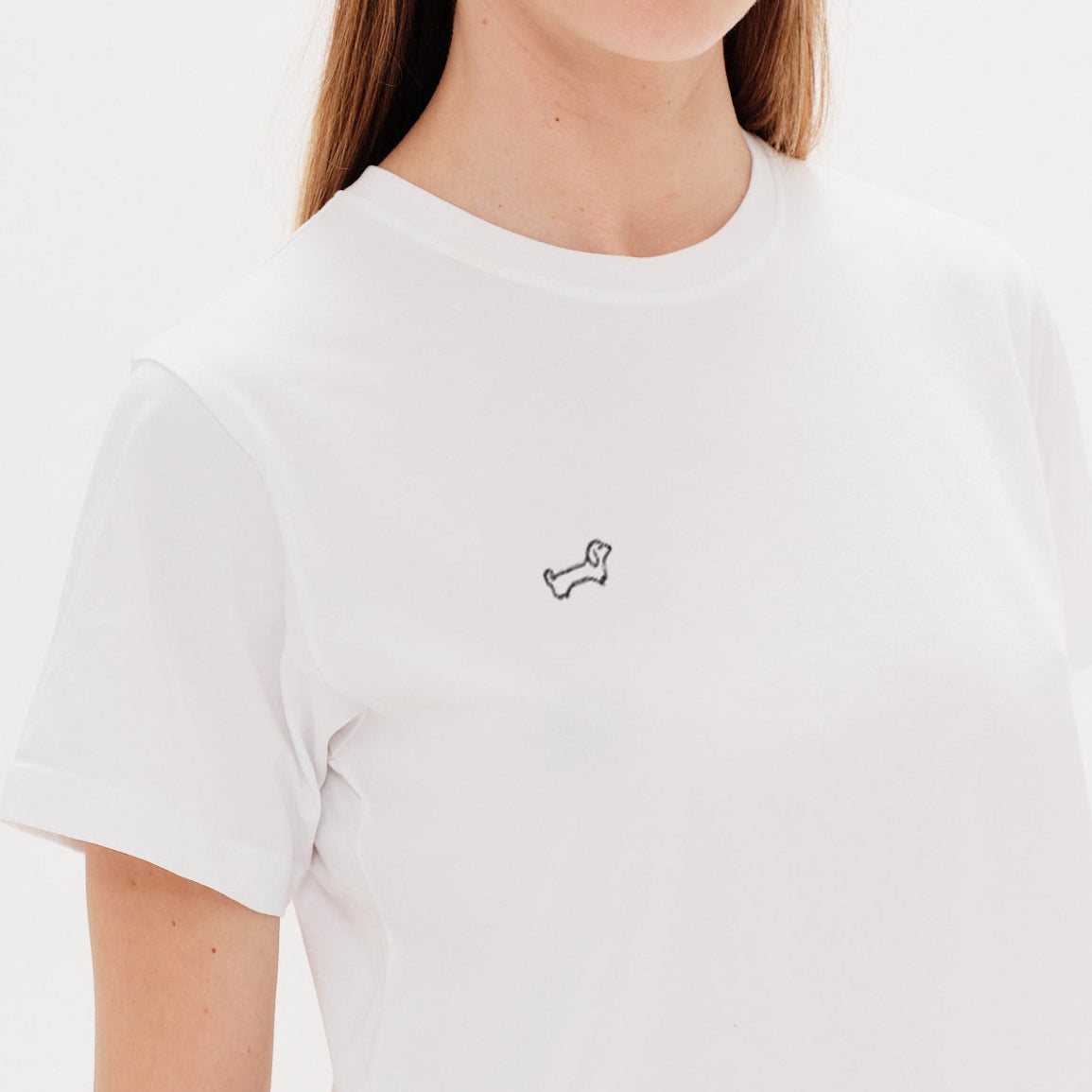 Woman wearing a white t-shirt with a wiener dog embroidery
