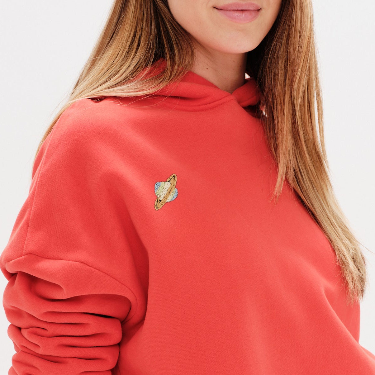 Woman wearing a premium black hoodie with a planet embroidery