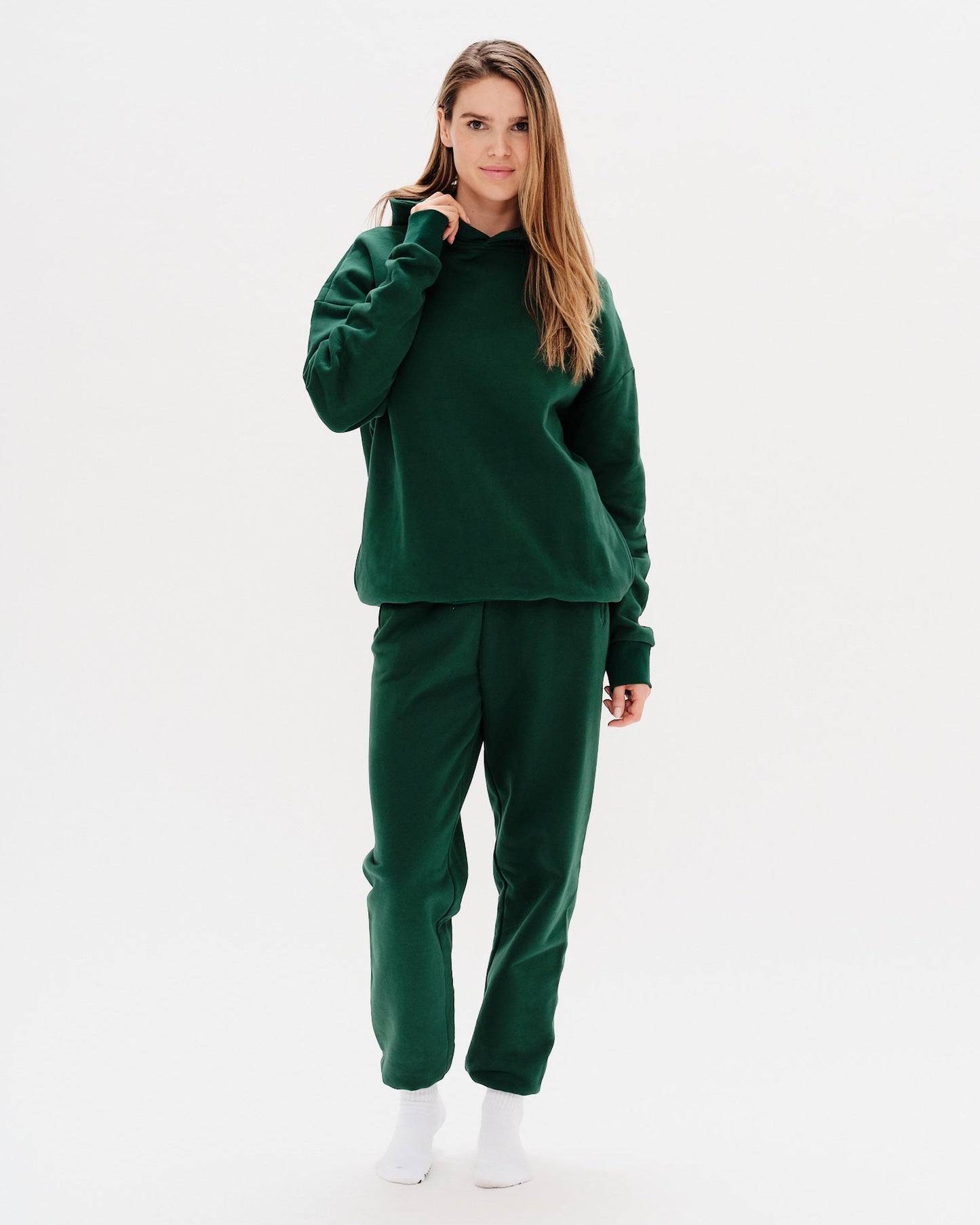 Woman wearing green pants with West Village embroidery