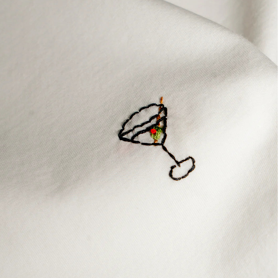 Embroidered cocktail glass with a cherry on a white t-shirt background
