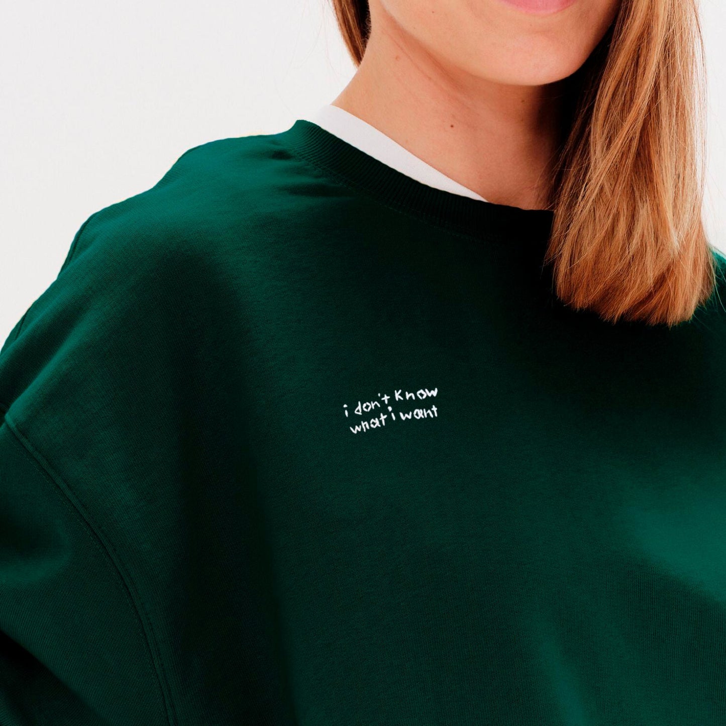 Green sweatshirt with text 'i don't know what i want' worn by a woman