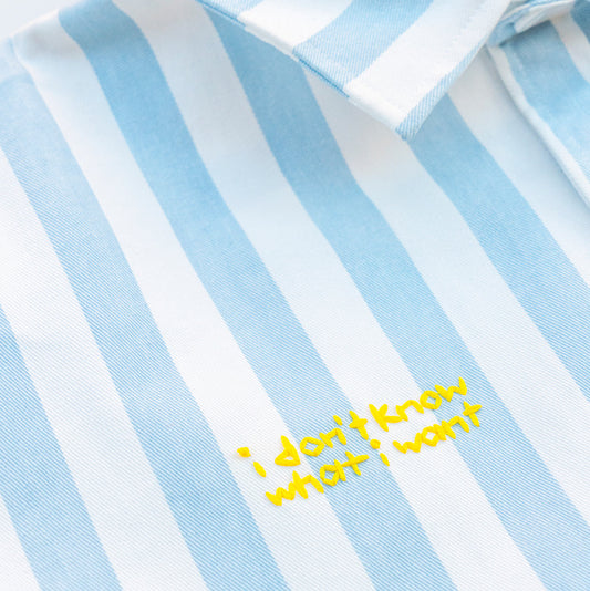 Blue and white striped shirt with yellow text 'I don't know what I want' on a close-up view.