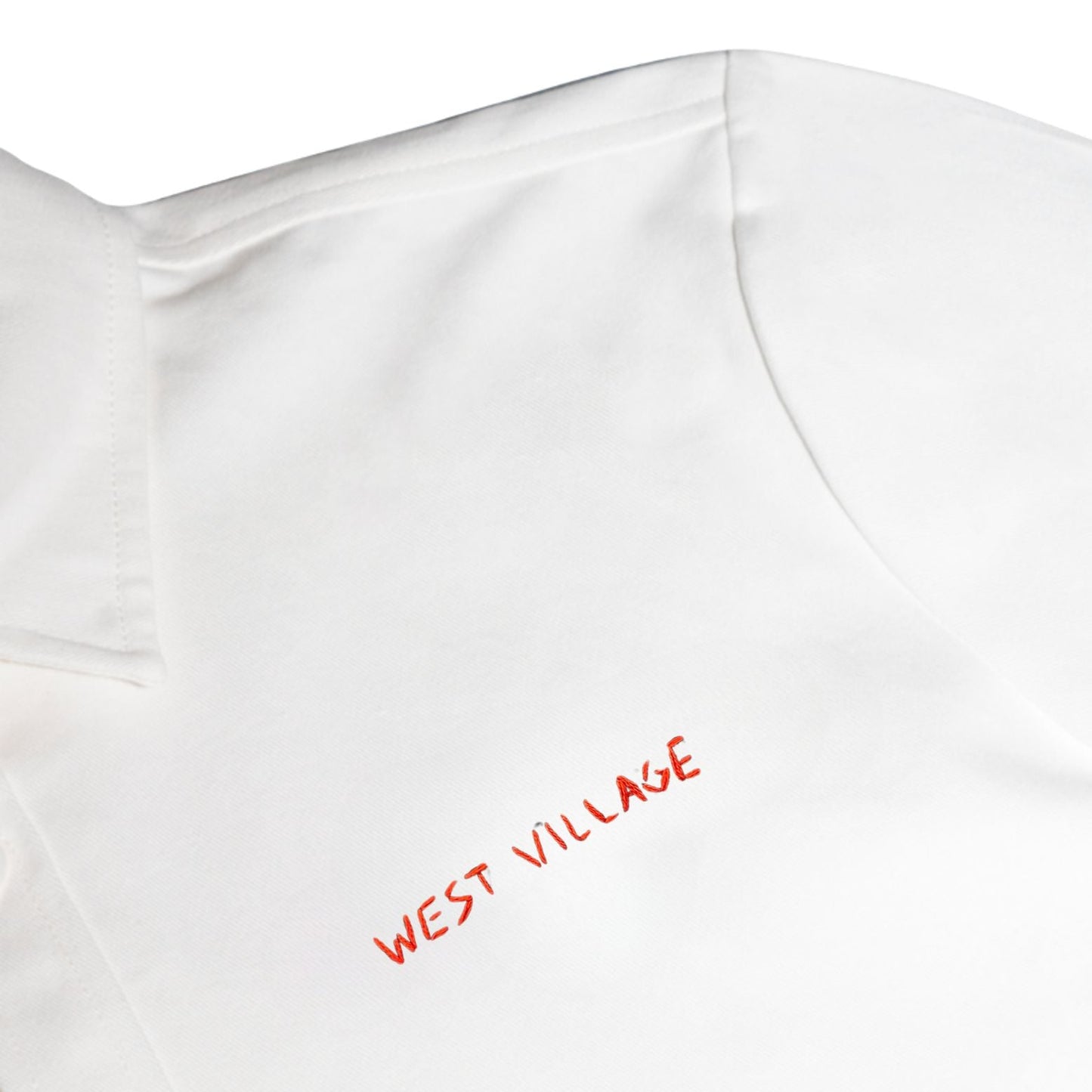 White shirt with 'WEST VILLAGE' embroidered in red on a white background