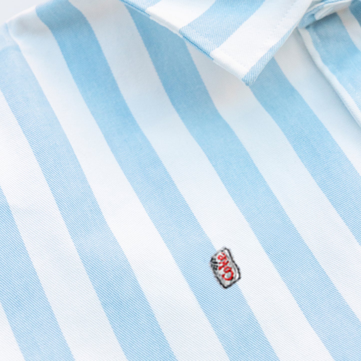 Woman wearing a striped shirt with a Diet Coke embroidery