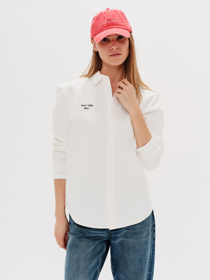 Woman wearing a white shirt with a New York Boy embroidery