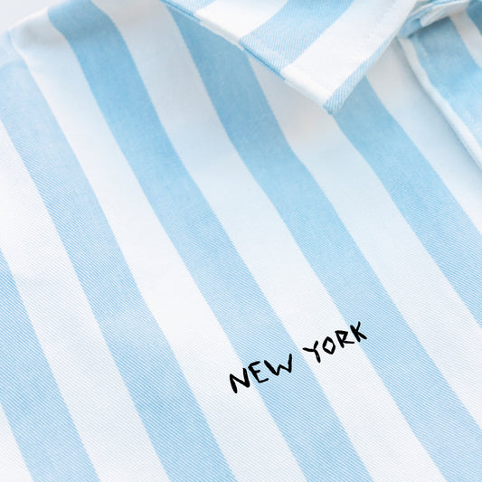 Woman wearing a striped shirt with a New York embroidery