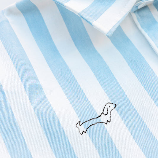 Woman wearing a striped shirt with a Weiner Dog embroidery