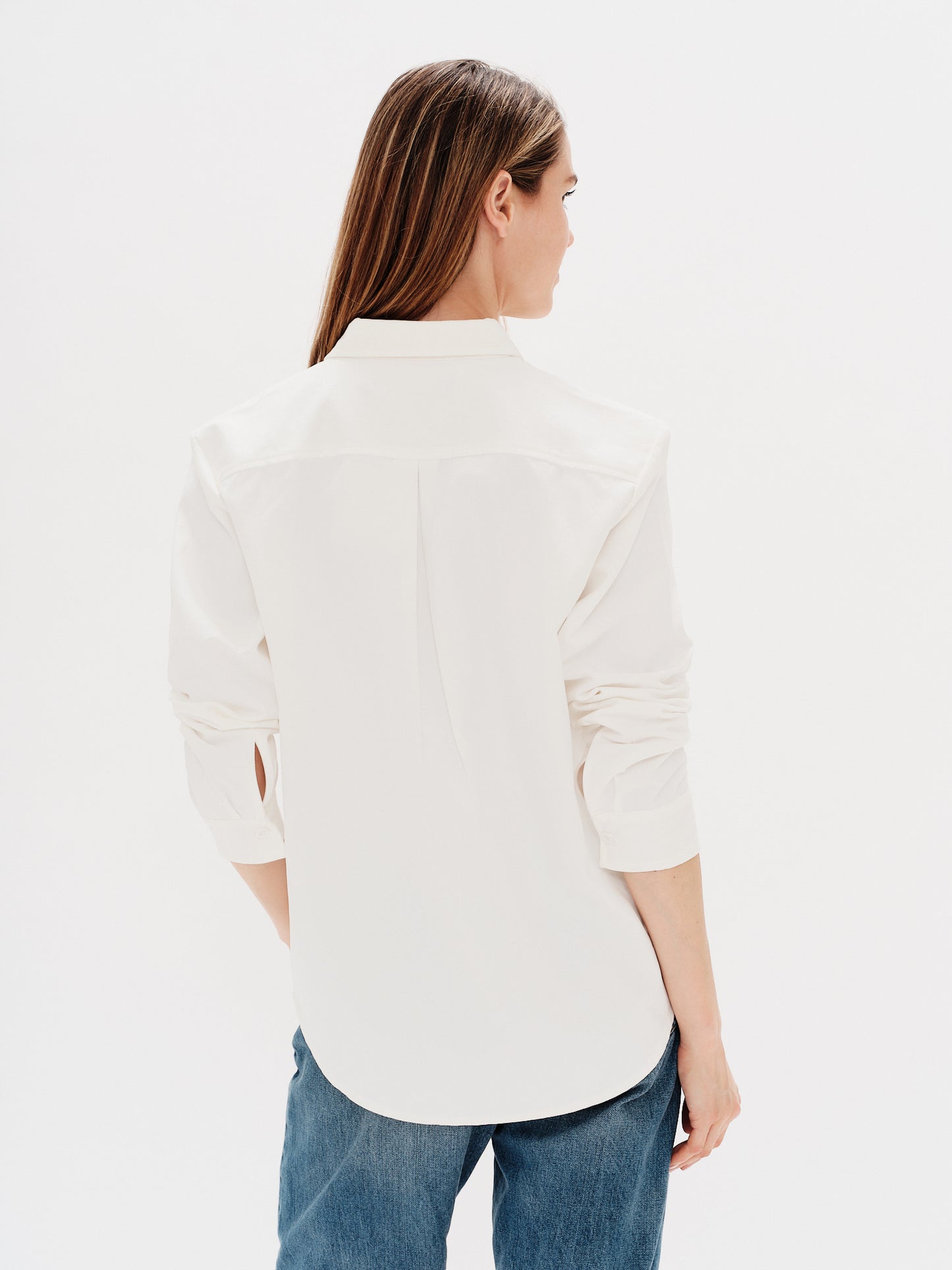 Woman wearing a white shirt with i don't want to work embroidery