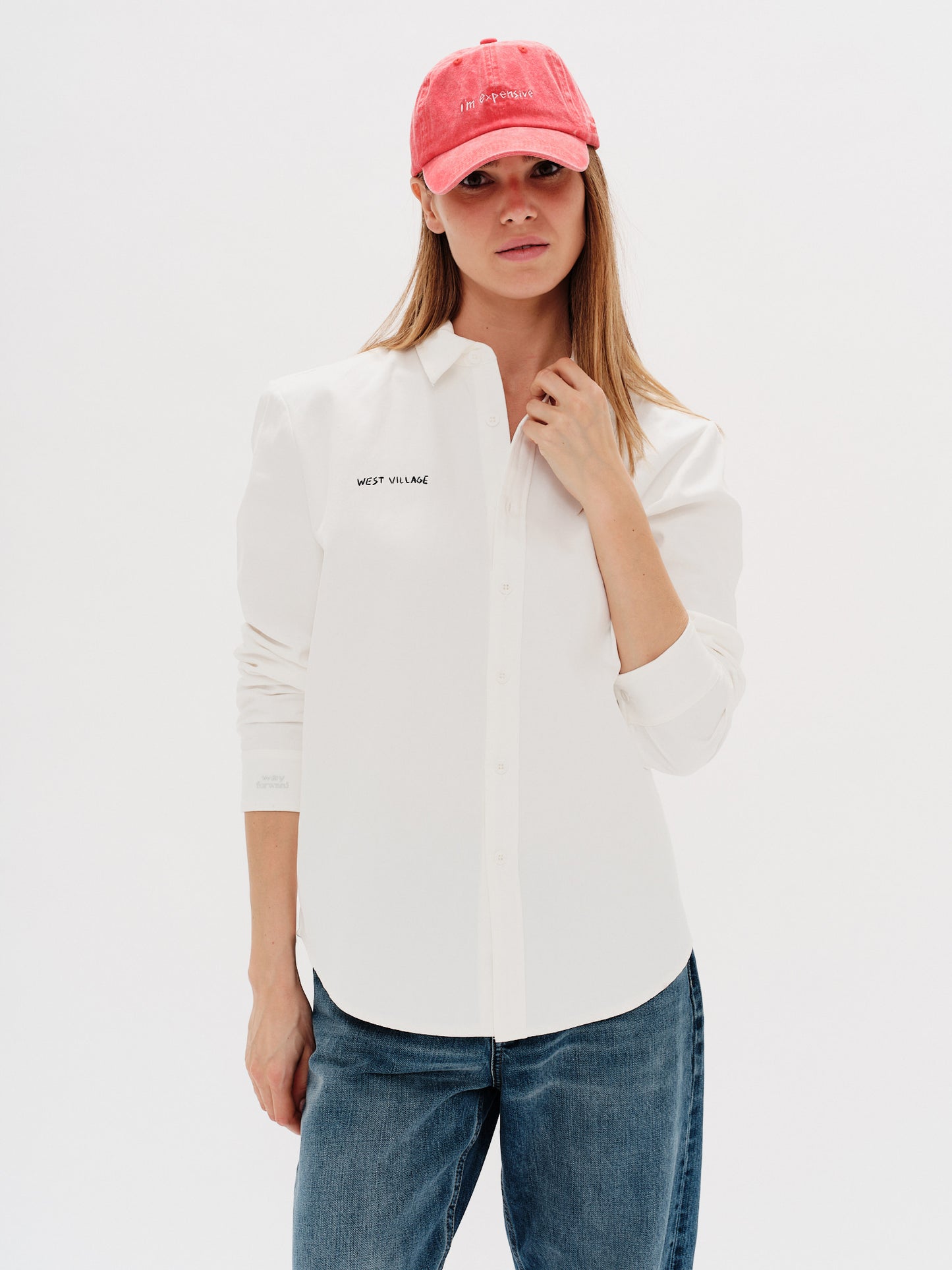 Woman wearing a white shirt with West Village embroidery