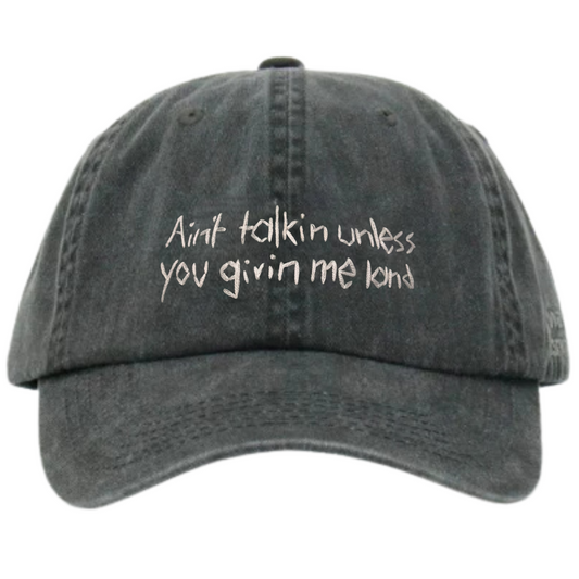 A black wash cotton cap with white text embroidery that reads 'Ain't talkin unless you givin me land'.
