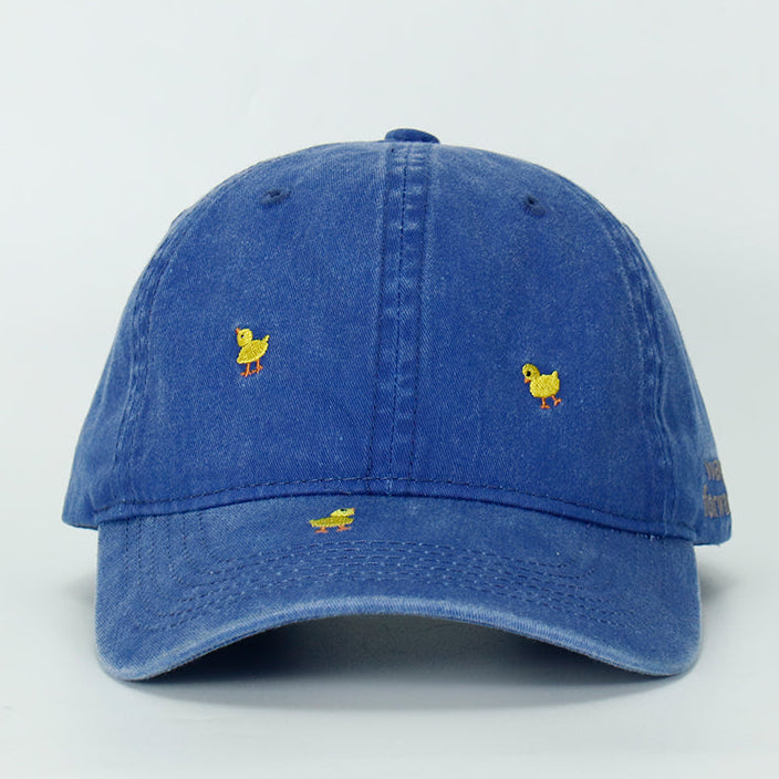 A blue wash baseball cap with embroidered yellow duck designs on it, displayed against a plain background.