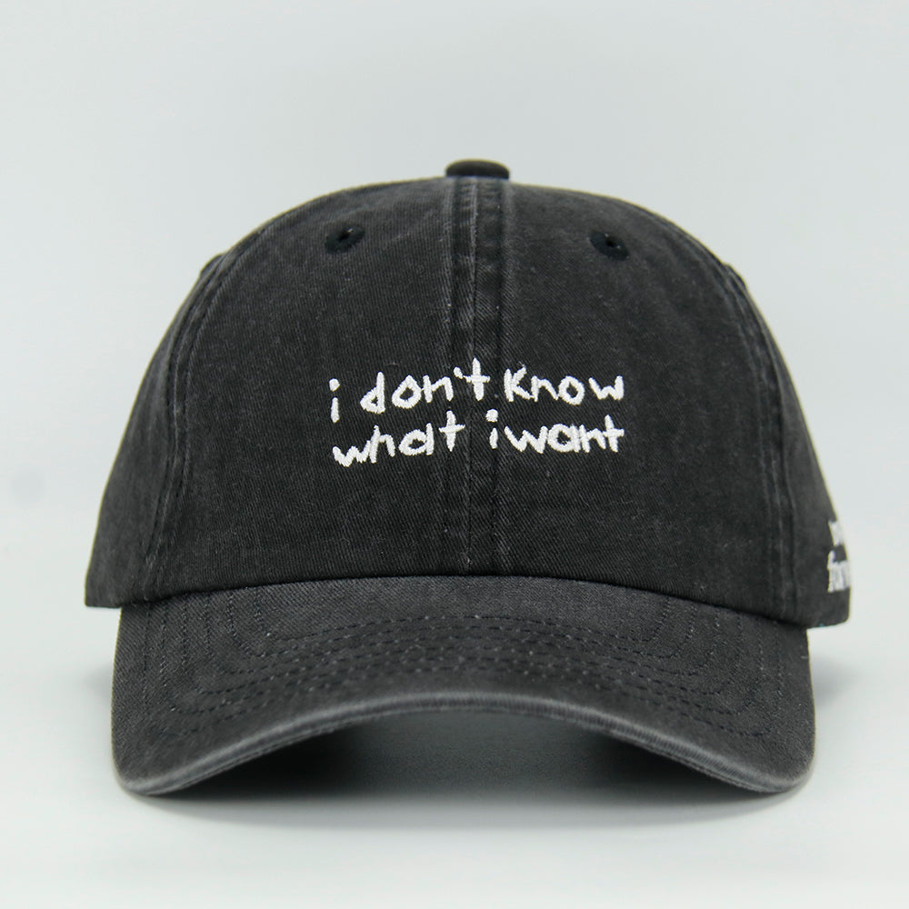 A black baseball cap with the embroidered text 'i don't know what i want' in white.
