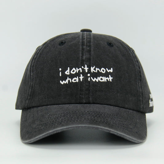 A black baseball cap with the embroidered text 'i don't know what i want' in white.