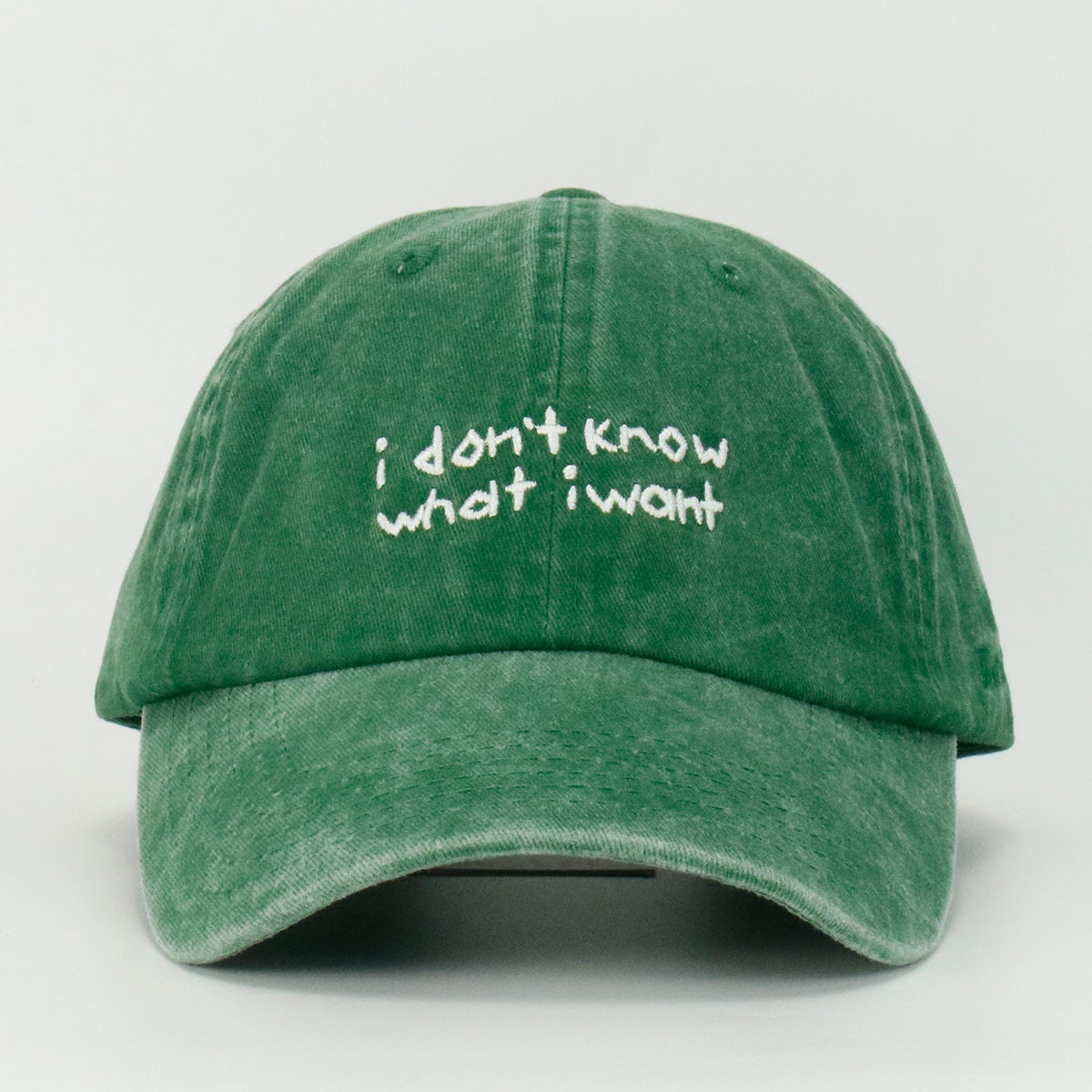 A green baseball cap with the embroidered text 'i don't know what i want' in white.