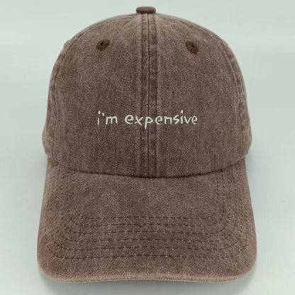 A brown wash baseball cap with the phrase 'I am expensive' embroidered on the front.