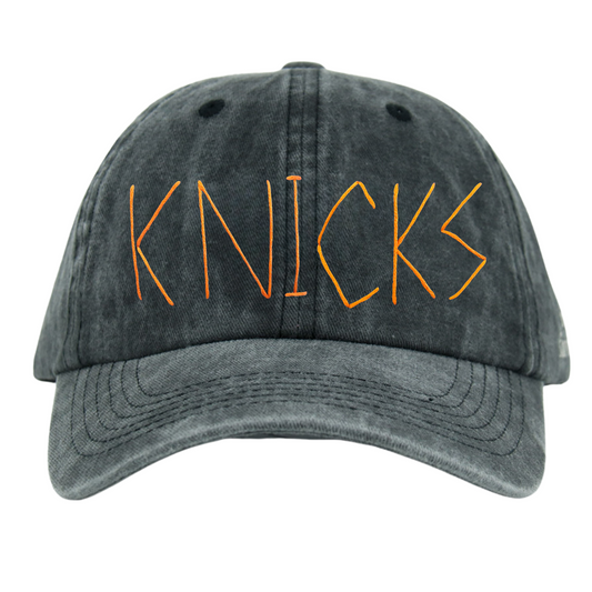 A black wash baseball cap with the word 'KNICKS' embroidered in orange on the front.