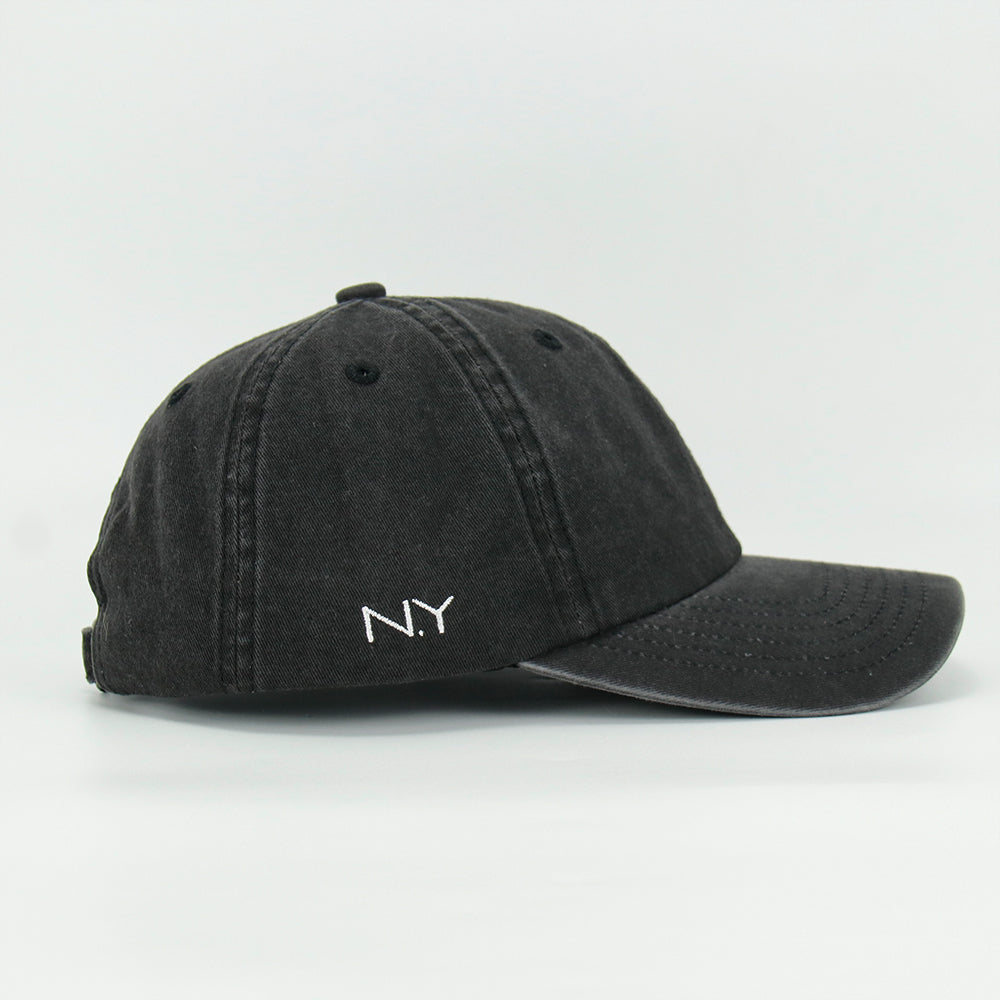 A black wash cotton baseball cap with a embroidered 'Martini' NY logo on the side, featuring an adjustable strap at the back.