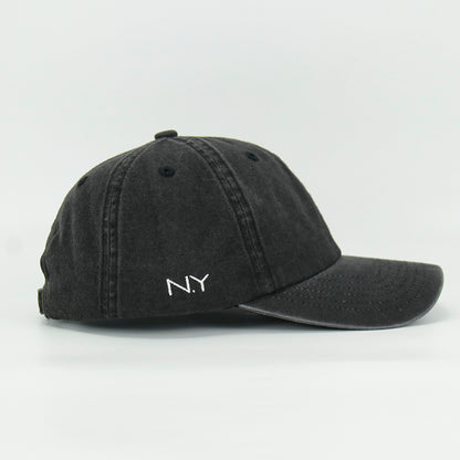 A black wash cotton baseball cap with a embroidered 'Martini' NY logo on the side, featuring an adjustable strap at the back.