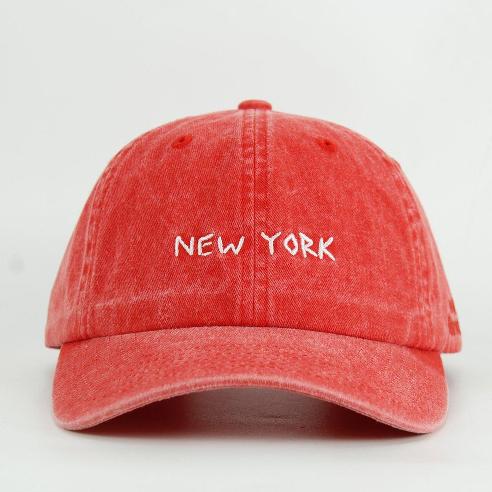 Red washed cap with 'NEW YORK' text on a white background