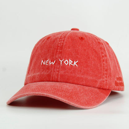 Red washed cap with 'NEW YORK' text on a white background