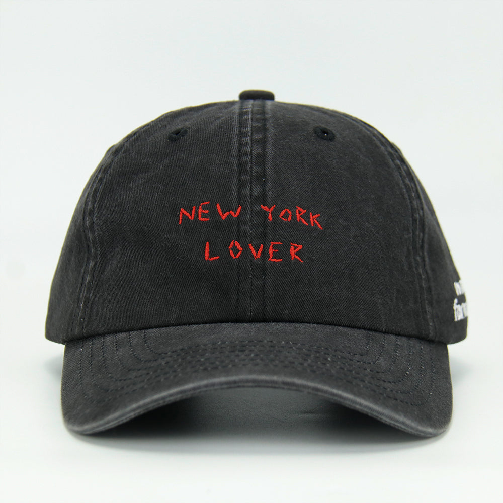 A black baseball cap with 'NEW YORK LOVER' embroidered on the front.