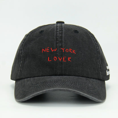 A black baseball cap with 'NEW YORK LOVER' embroidered on the front.