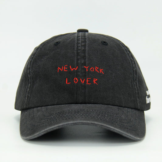 A black baseball cap with 'NEW YORK LOVER' embroidered on the front.