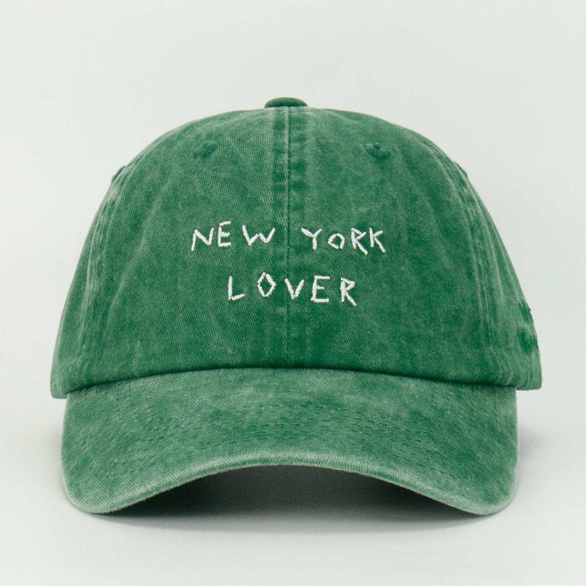 A green wash baseball cap with 'NEW YORK LOVER' embroidered on the front.