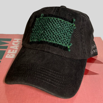 A black baseball cap with a green patch on the front.