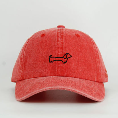 Red cap with a black dog embroidery design on a light gray background