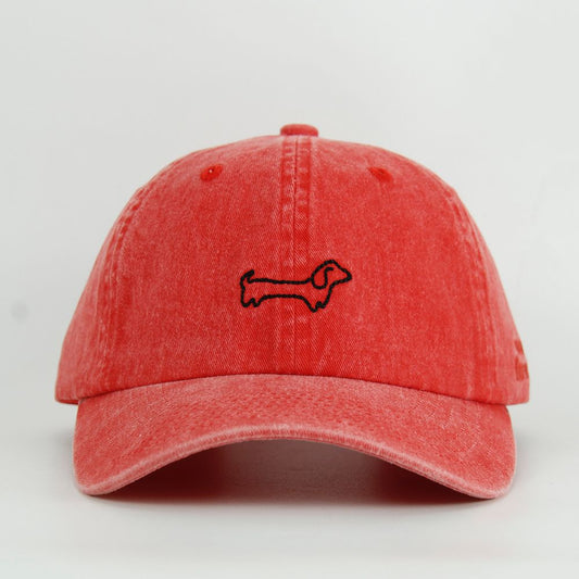 Red cap with a black dog embroidery design on a light gray background