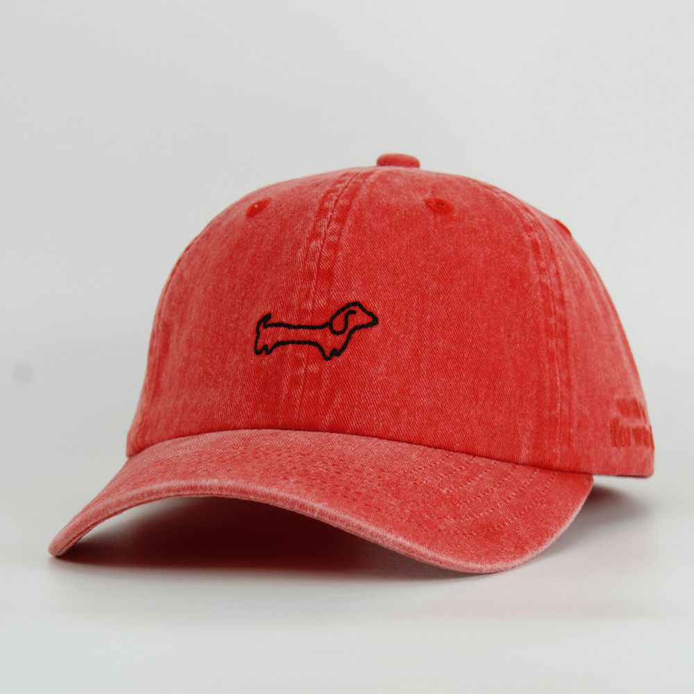 Red cap with a black dog embroidery on a light gray background
