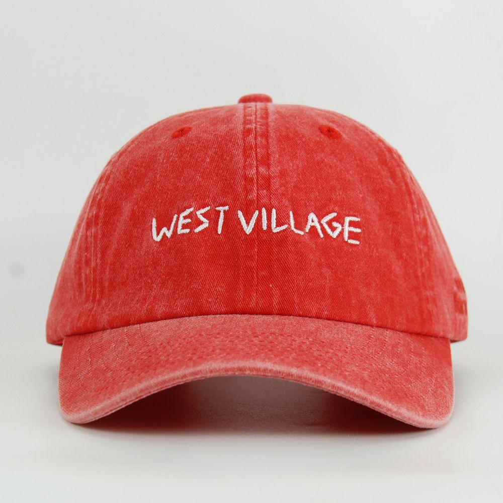Red cap with 'WEST VILLAGE' text on a light gray background