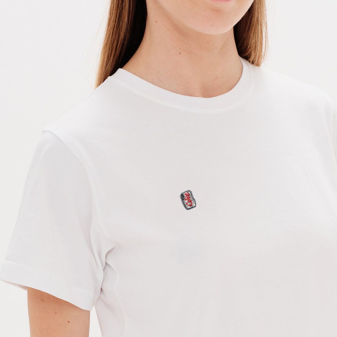 Woman wearing a white t-shirt with a diet coke embroidery