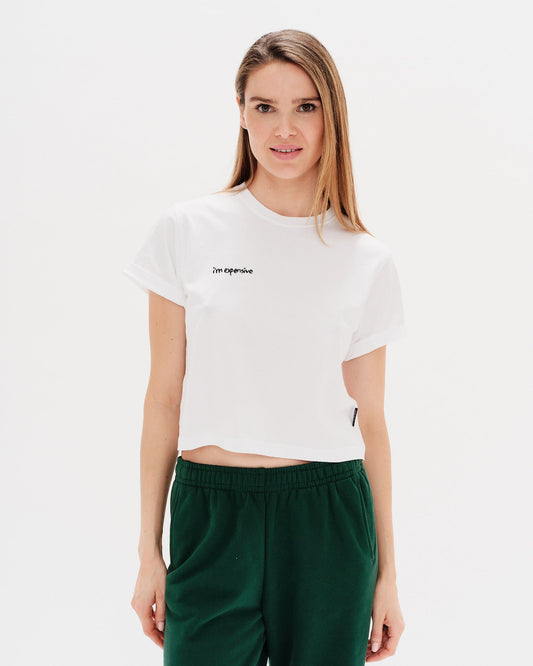 Woman wearing a white t-shirt with an I'm expensive embroidery