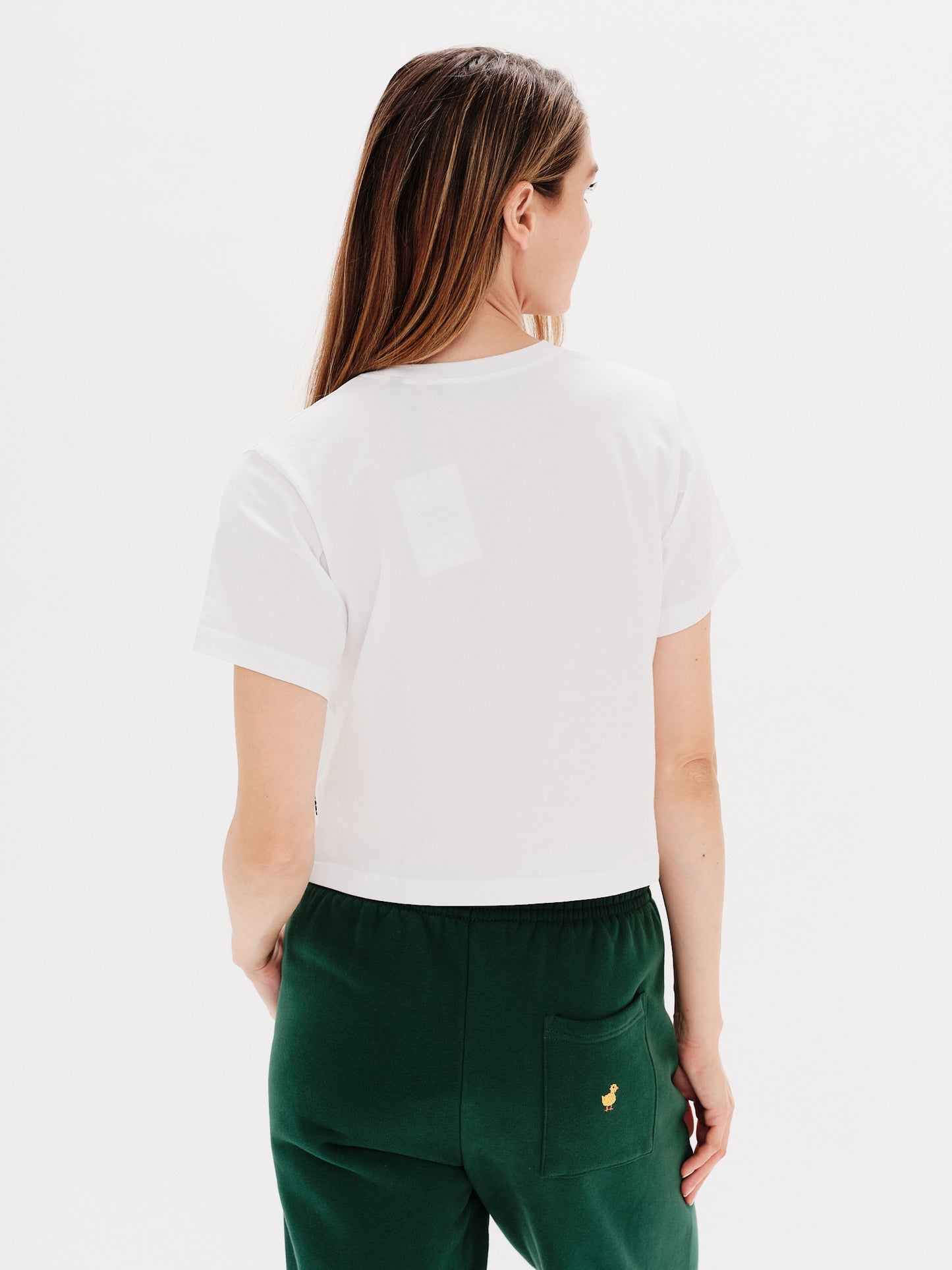 Woman wearing a white t-shirt with an I'm expensive embroidery