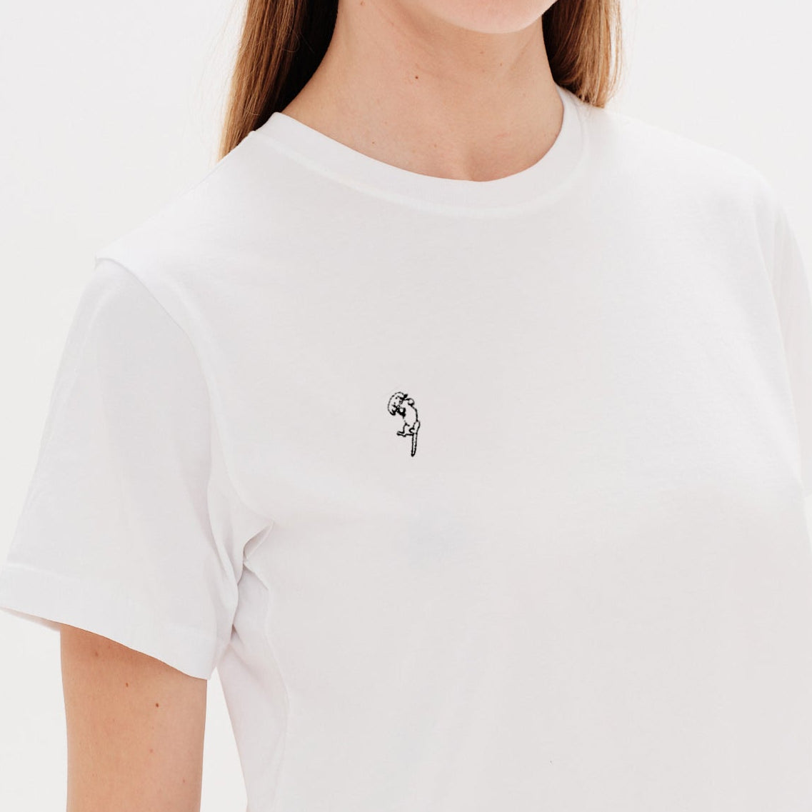 Woman wearing a white t-shirt with a long hair wiener dog embroidery