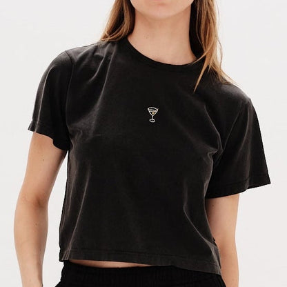 Woman wearing a black t-shirt with a martini embroidered design