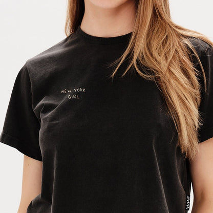 Woman wearing a black t-shirt with a New York Girl embroidery