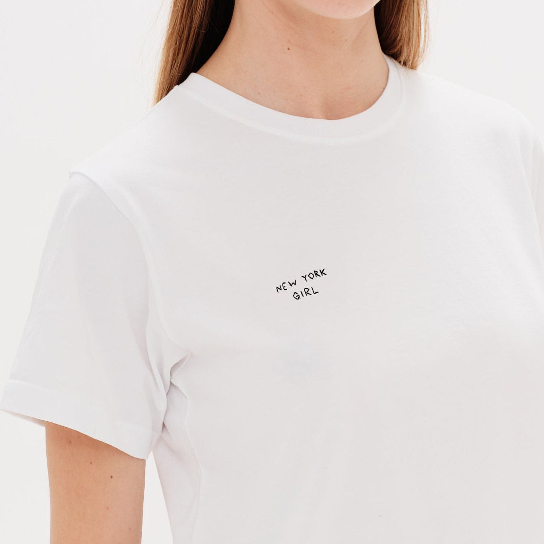 Woman wearing a white t-shirt with a New York Girl Embroidery