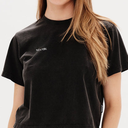 Woman wearing a black t-shirt with a New York embroidery