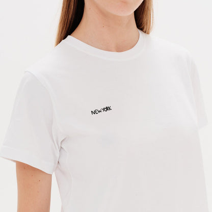 Woman wearing a white t-shirt with a New York embroidery