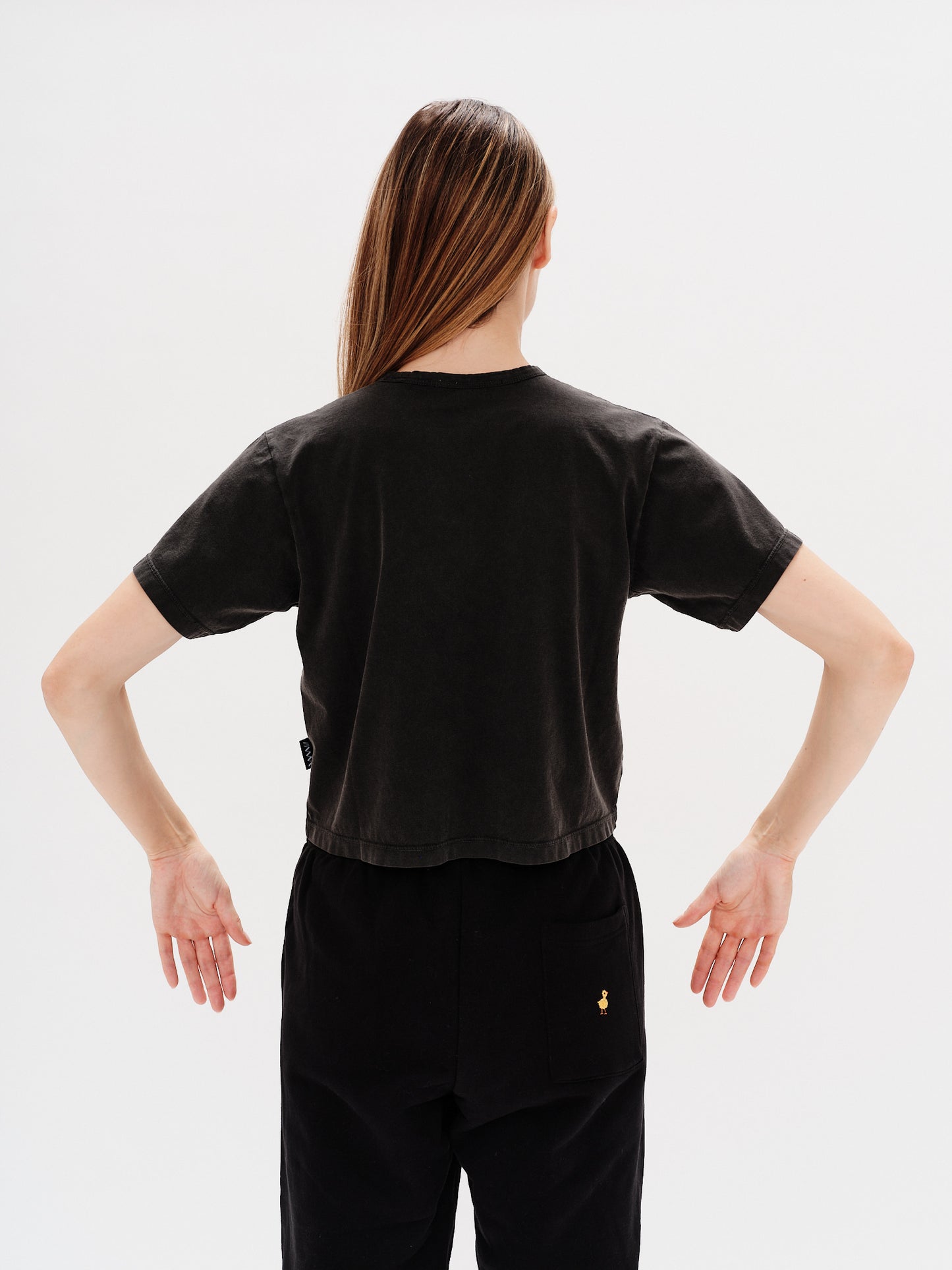 Woman wearing a black t-shirt with a planet embroidery