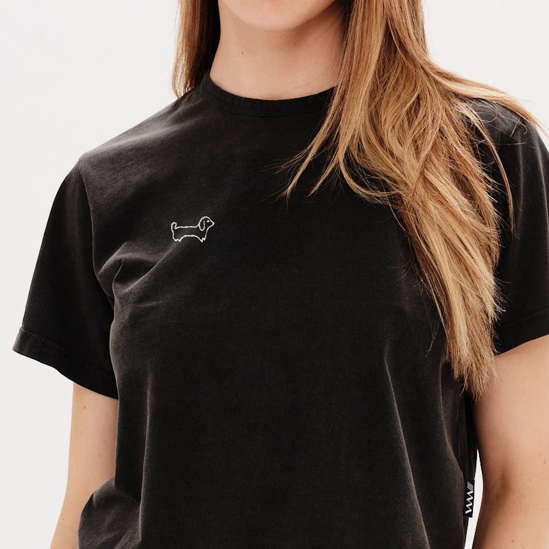 Woman wearing a black t-shirt with a wiener dog embroidery