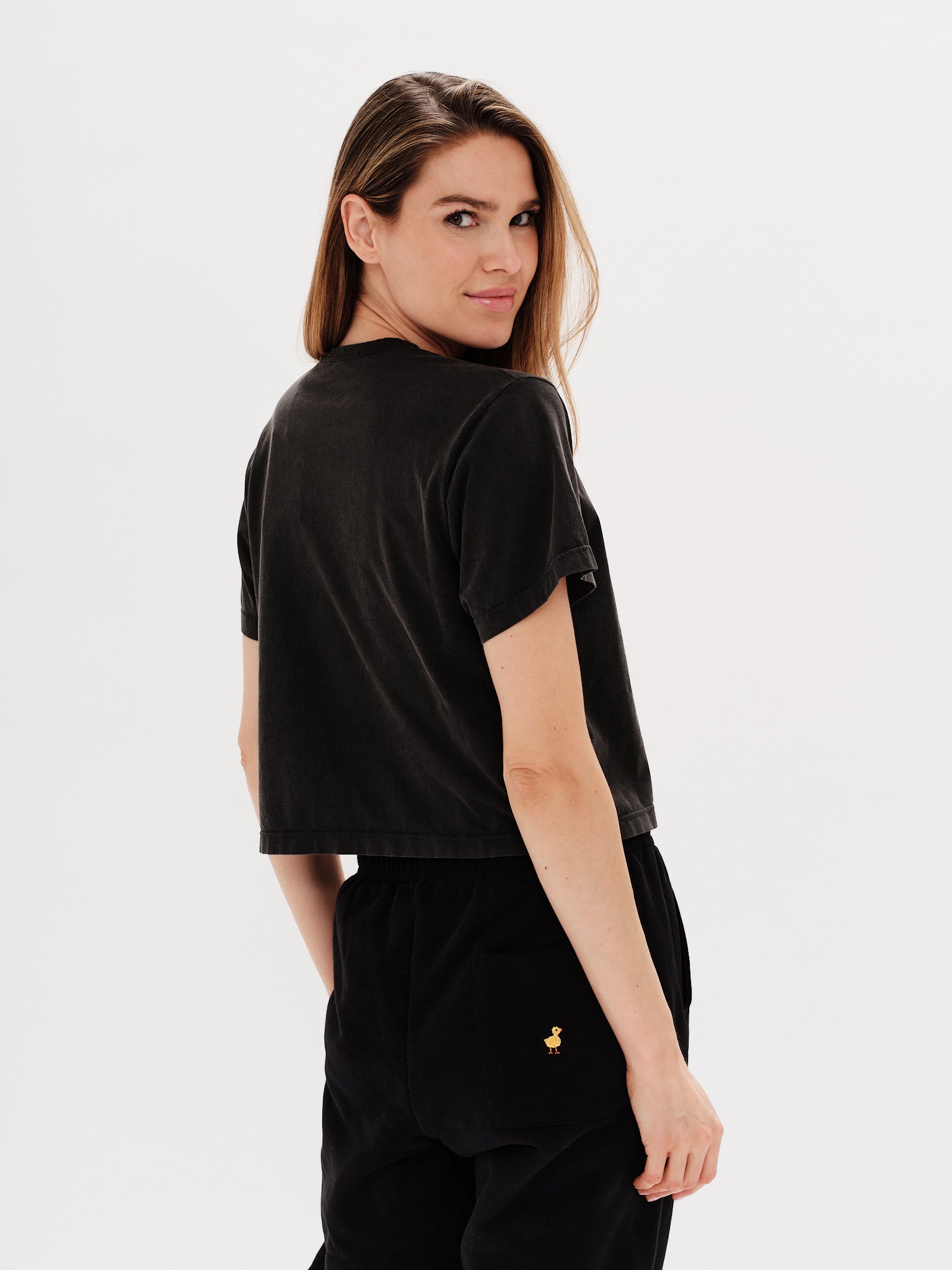 Woman wearing a black t-shirt with a wiener dog embroidery